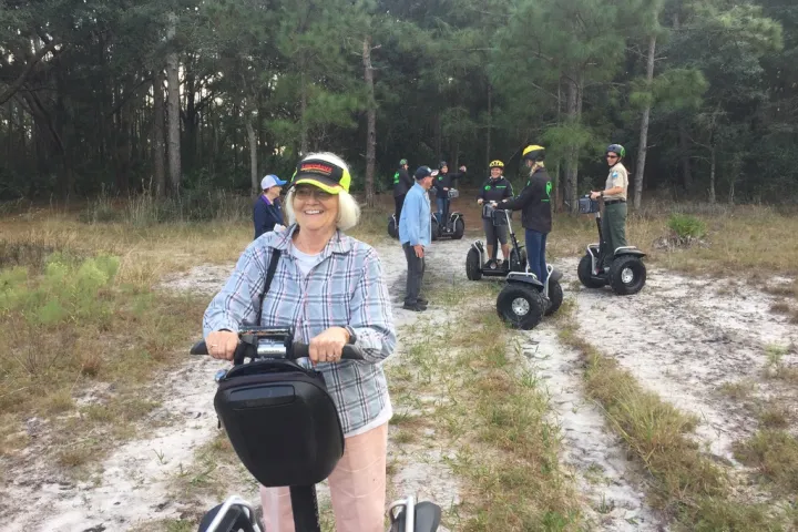 a man riding a motorcycle down a dirt road
