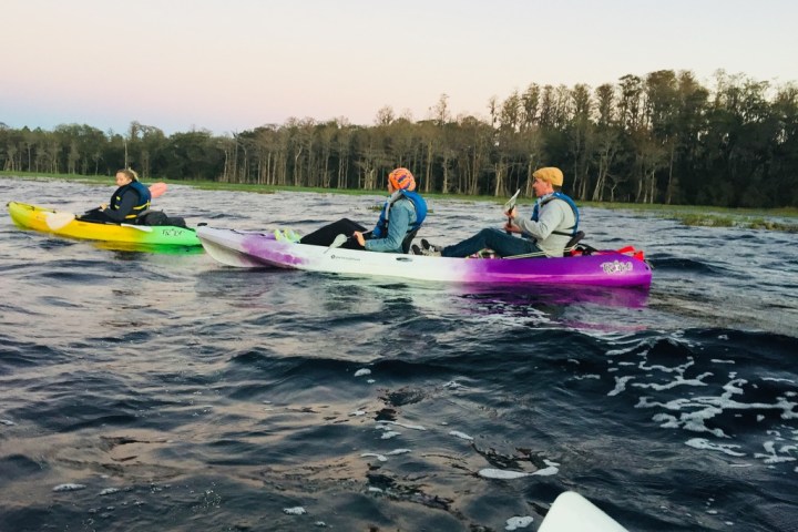 a group of people riding on the back of a boat in the water